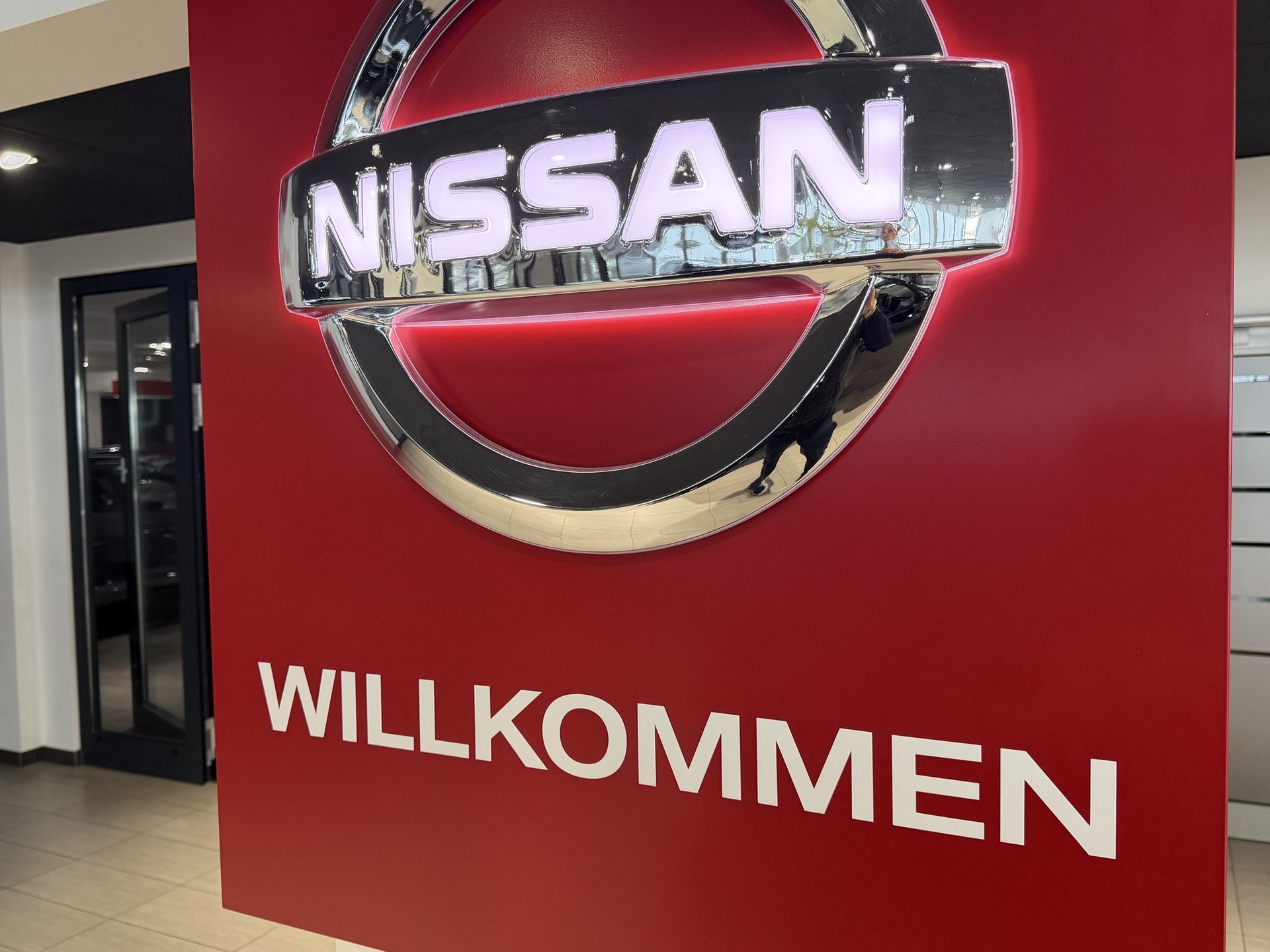 Beleuchtetes Nissan-Logo mit Schriftzug Willkommen im Empfangsbereich